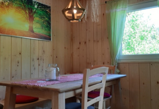 Sala da pranzo rivestita in legno in un glamping lodge a Boerderij Gallushof, Foresta Nera, Germania.