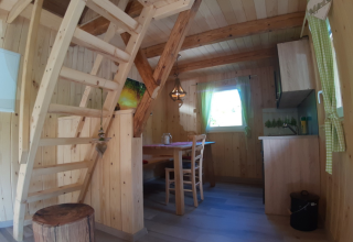 Binnenzicht glamping-lodge van Gallushof in het Zwarte Woud, Duitsland, met houten trap en eethoek.