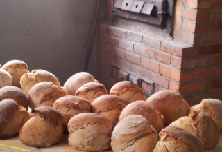 Pagnotte appena sfornate davanti a un forno a mattoni a Boerderij Gallushof, Foresta Nera, Germania.