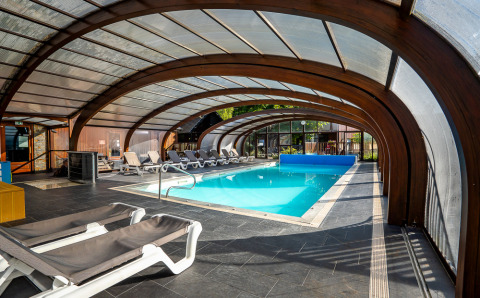 Piscine couverte avec transats à l’Auberge et Chalets de la Wormsa - Glamping Vogezen, ambiance détente et confort.