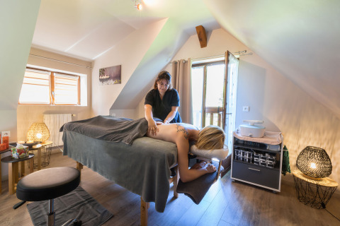 En afslappende massagebehandling gives i et hyggeligt, naturligt oplyst rum på Auberge et Chalets de la Wormsa.