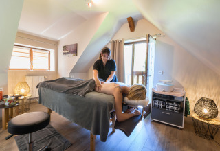 Entspannende Massage in einem gemütlichen Raum mit natürlichem Licht bei Auberge et Chalets de la Wormsa.