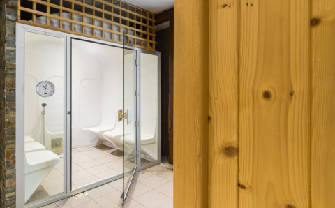 Moderne dampbadsauna med hvide bænke og glasdør på Auberge et Chalets de la Wormsa - Glamping Vogezen.