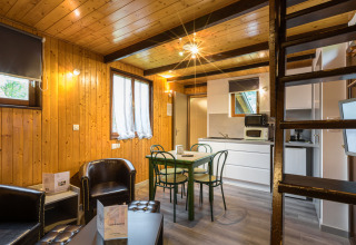 Indretning af glampingbolig hos Auberge et Chalets de la Wormsa med træpaneler, spisebord og køkken.