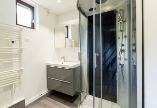 Baño moderno con cabina de ducha, lavabo y espejo en Auberge et Chalets de la Wormsa - Glamping Vogezen.