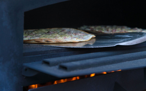 En pizza bages i en brændefyret ovn ved Auberge et Chalets de la Wormsa - Glamping Vogezen campingplads.