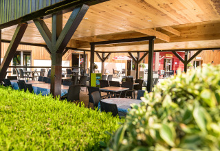 Terraza al aire libre cubierta en Auberge et Chalets de la Wormsa Glamping Vogezen, con mesas y sillas.