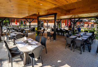 Udendørs spiseområde på Auberge et Chalets de la Wormsa - Glamping Vogezen med dækkede borde og stole.