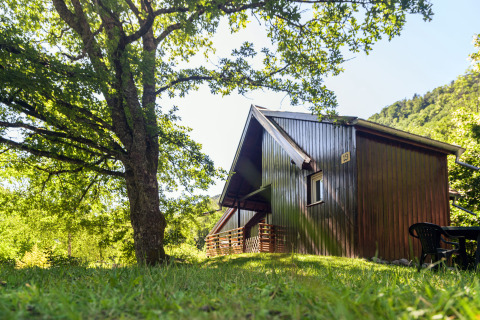 Cabaña de madera en claro del bosque en Auberge et Chalets de la Wormsa, glamping en los Vosgos, rodeada de naturaleza.