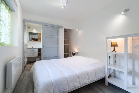 Lichte slaapkamer met tweepersoonsbed en minimalistisch interieur in Auberge et Chalets de la Wormsa - Glamping Vogezen.