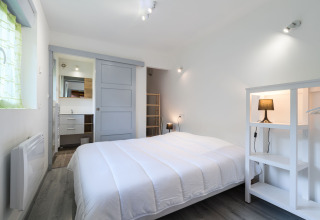 Chambre lumineuse avec lit double et déco épurée à l’Auberge et Chalets de la Wormsa - Glamping Vogezen.