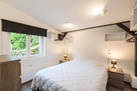 Lichte en knusse slaapkamer bij Auberge et Chalets de la Wormsa Glamping Vogezen met raam en groen uitzicht.
