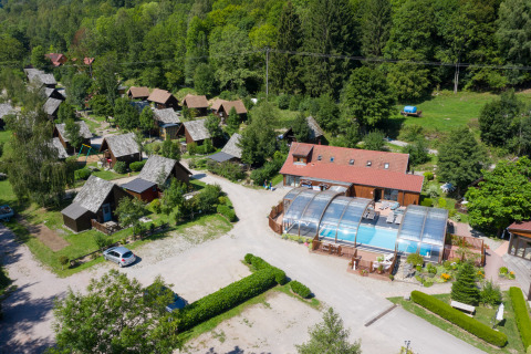 Vista aerea di Auberge et Chalets de la Wormsa Glamping Vogezen con chalet in legno e piscina coperta.