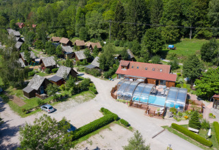 Vista aerea di Auberge et Chalets de la Wormsa Glamping Vogezen con chalet in legno e piscina coperta.