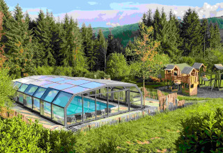 View of Domaine la Chabanne glamping with a covered swimming pool and playground in Auvergne-Rhône-Alpes.