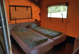 Interior view of a glamping accommodation with two single beds at Domaine la Chabanne, Auvergne-Rhône-Alpes.