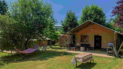 Glamping accommodatie met safaritent bij Domaine la Chabanne in Auvergne-Rhône-Alpes, hangmat en tafel.