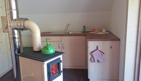 Binnenkeuken in Vollmershof - Lodge Zwarte Woud glamping met houtkachel, spoelbak en eigentijds meubilair.