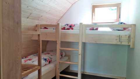 Camas literas acogedoras con ropa de cama floral en Vollmershof - Lodge Zwarte Woud, alojamiento glamping.