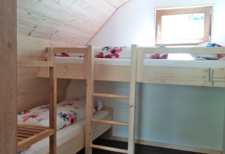 Hytteindkvartering med køjesenge og blomstret sengetøj på Vollmershof - Lodge Zwarte Woud, glamping.