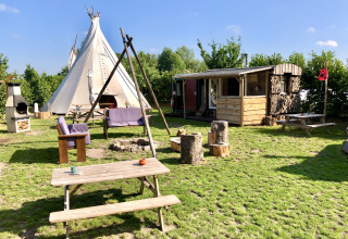 Glampinglocatie met tipi, houten hut en buitenzitjes bij Glamping 't Buitenland in Nederland.