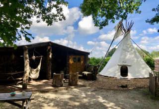 Glamping 't Buitenland med Finse Kota, yurt, tipitelt og pipowagen under blå himmel med skyer.