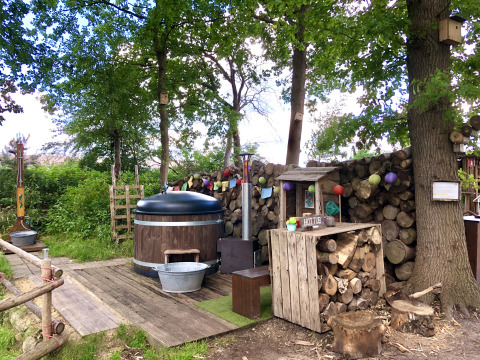 Udendørs spa og træomgivelser på glampingpladsen Glamping 't Buitenland med hyggelig atmosfære.