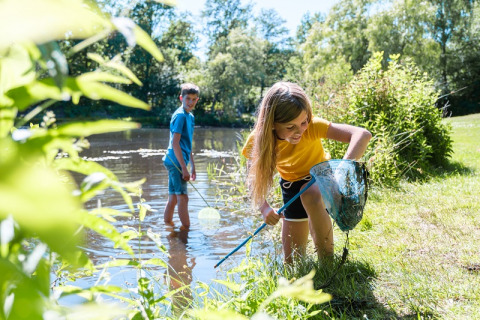 Due bambini che pescano al lago presso Camping de Pallegarste - Safaritenten Overijssel in una giornata di sole.