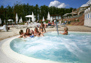 Bambini si divertono in una vasca idromassaggio al Chianti Glamping Resort in Toscana, tra lettini e ombrelloni.