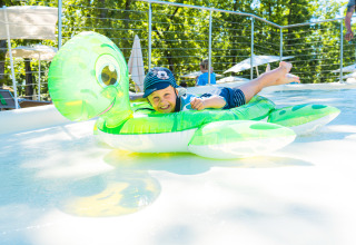 Een kind speelt op een schildpad opblaasbare in een zwembad bij Chianti Glamping Resort - Safaritenten Toscane.