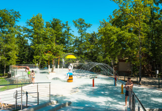 Kinderen spelen in een waterspeelzone tussen bomen bij Chianti Glamping Resort in Toscane, Italië.