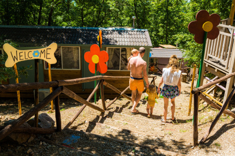 Famiglia scende i gradini al Chianti Glamping Resort in Toscana, vicino a decorazioni colorate e benvenuto.