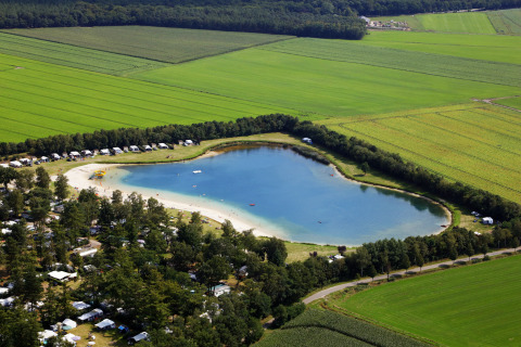 Vista aerea di Recreatiepark de Achterste Hoef con tende safari glamping e lago nel Brabant, Paesi Bassi.