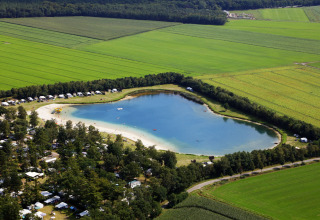 Luftaufnahme vom Campingplatz Recreatiepark de Achterste Hoef mit Safarizelten und See in Brabant.