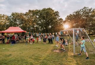 Fête en plein air au Recreatiepark de Achterste Hoef, Safaritenten Brabant, avec familles et enfants qui jouent.