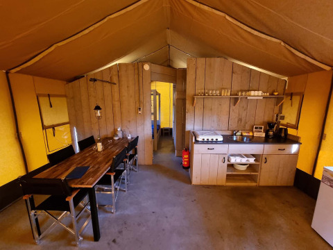 Interior of a safari tent at Recreatiepark de Achterste Hoef with dining area and kitchenette in Brabant.