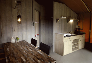 Indendørs glampingindkvartering med spisebord og tekøkken i Safaritenten Brabant, Recreatiepark de Achterste Hoef.
