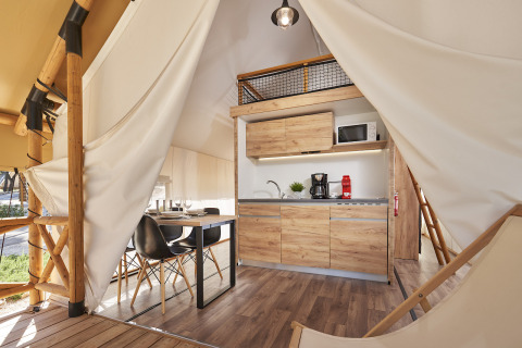 Moderne glampingaccommodatie met houten interieur, keuken en eethoek in Glamping Village Kötschach.