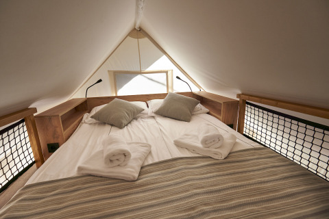 Interior view of a cozy bed in Glamping Village Kötschach - Safaritenten Karinthië accommodation.