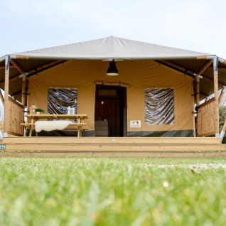 Hébergement glamping au Trixi Ferienpark en Saxe, tente safari avec terrasse, table de pique-nique et pelouse.
