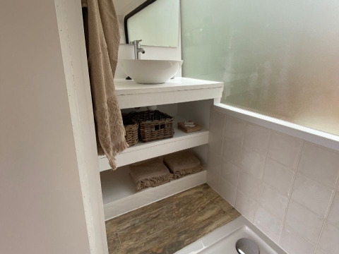 Bagno nell'alloggio glamping Algarve Olive Tree Lodge con lavandino, specchio e ripiani portaoggetti.