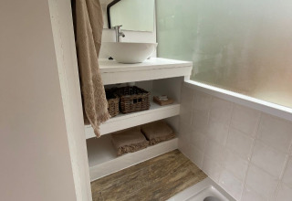 Baño de alojamiento glamping Algarve Olive Tree Lodge con lavabo, espejo y estantes para almacenamiento.