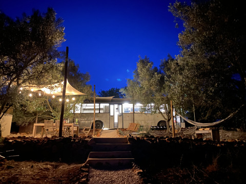 Glamping suggestivo con vecchio scuolabus, amaca e luci tra ulivi presso Algarve Olive Tree Lodge.