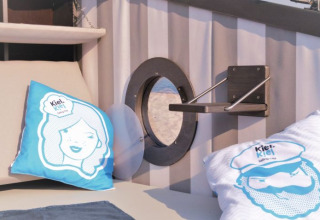 Alloggio glamping con cuscini nautici, oblò e mensola a Kiel Sailing City, Kieler Fjord.