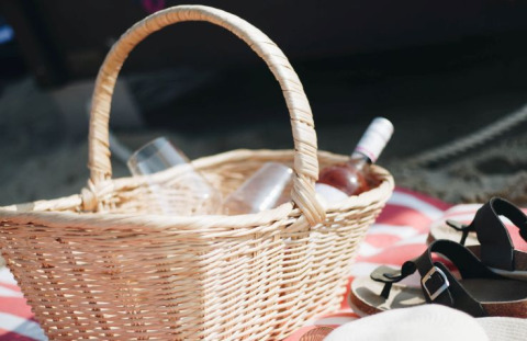 Picknickkorb mit Weinglas und Flasche auf Decke, perfekt für Glamping in Kiel Sailing City - Strandmand.