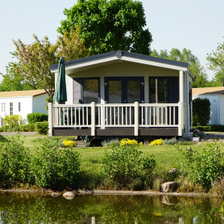 Luxe chalets aan een meer op Camping Südsee-Camp, met houten terras en veel natuur in Nedersaksen.
