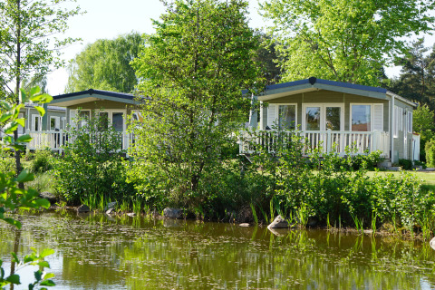Chalet di lusso per glamping accanto a uno stagno al Camping Südsee-Camp in Bassa Sassonia, Germania.