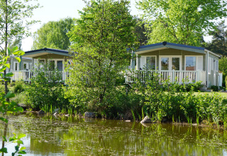 Chalet di lusso per glamping accanto a uno stagno al Camping Südsee-Camp in Bassa Sassonia, Germania.