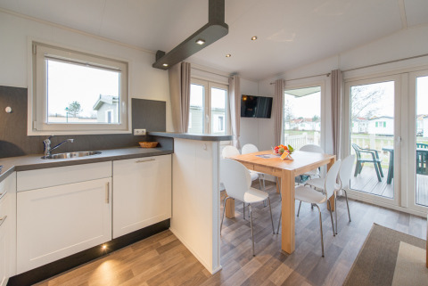 Alojamiento glamping moderno en Camping Südsee-Camp con comedor elegante y cocina americana equipada.