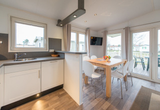 Moderne glamping-indkvartering på Camping Südsee-Camp med luksuriøst interiør, spisebord og køkken.